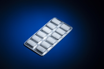 Package of nicotine gum on dark blue background