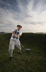 Golfer missing the ball in the rough.