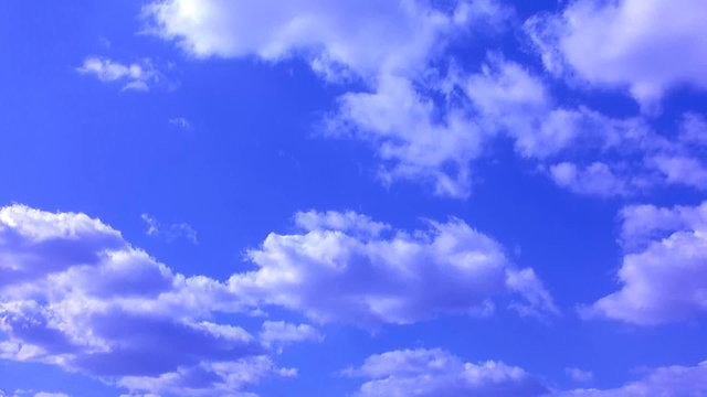 White cumulus clouds in the blue sky, time lapse clip.