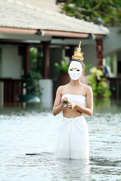 Mask woman playing thai traditional music instrument