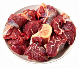 red raw meat  over white on wooden plate