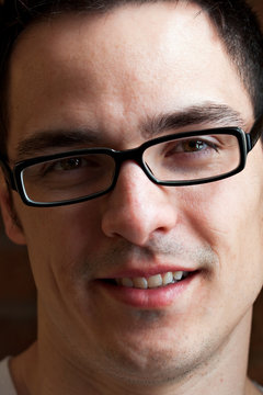 Handsome young adult man wearing black glasses