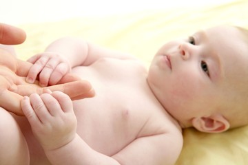 nude blond baby playing mother hands