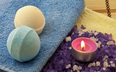 Fototapeta na wymiar Violet salt with candle and bath balls