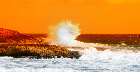 vague sur les rochers au coucher du soleil