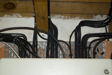 Black electrical cables on an old wall