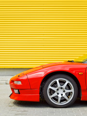 Plakat Side view of a front of red sportcar on yellow background