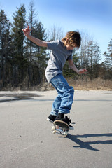 Young teen skateboarding on one wheel.