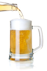 Beer is pouring into a glass from bottle