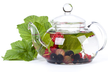 Teapot with fruit tea and green leaves