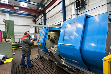 Obraz premium Older workers in the metal industry with CNC milling machine.