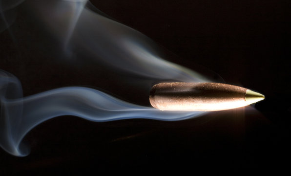 speeding bullet on a black background with lots of smoke trailing behind.