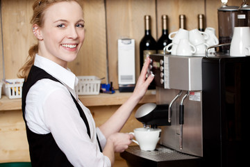 lächelnde kellnerin an der espressomaschine