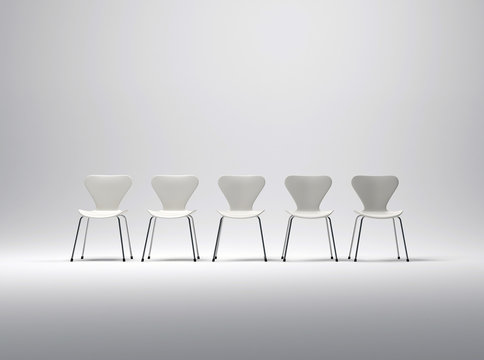 Row Of Five White Plastic And Metal Chairs