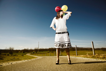 Fototapeta premium woman with balloons and headphones on a blue sky summer day