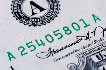 Close up view of the serial number of a dollar bill