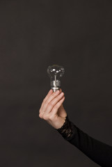 Hand holding a Bright Light Bulb, Concept of Inspiration, Ideas