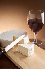slice camembert with glass of red wine