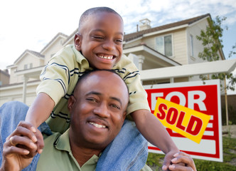 Father and Son In Front of Real Estate Sign and Home