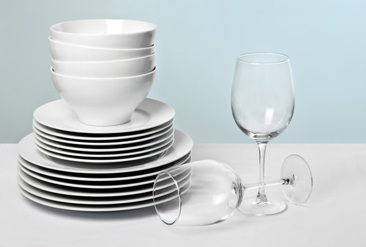 Stack of Commercial White Plate and Wine Glasses