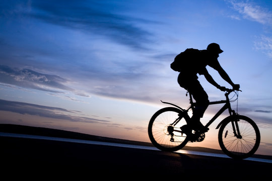 silhouette of cyclists in motion