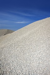 Fototapeta na wymiar gravel gray mound quarry stock blue sky