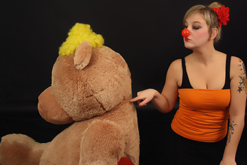 Foto de mujer payaso con oso de peluche gigante. Foto cómica - obrazy, fototapety, plakaty