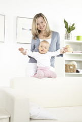 junge mutter mit baby auf weißem sofa