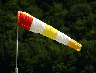 Windsock blows against a green forest