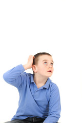 Young boy looking up and scratching head