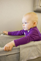 Naklejka premium sitting toddler girl travelling by plane