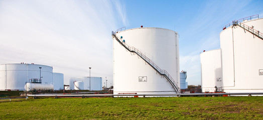 white tanks for petrol and oil in tank farm with blue sky