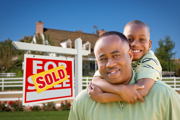 Father and Son In Front of Real Estate Sign and Home