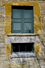 Fototapeta na wymiar Old Stone Wall with Window and Shutters