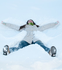 Beautiful girl in green lying in snow