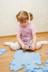 little girl collects puzzles in a room