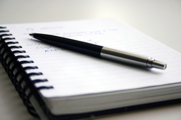 A black pen and notebook with words.