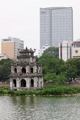 Fototapeta na wymiar ¯ółwie wieku wieża przeciwko nowego budynku biurowego w Hanoi