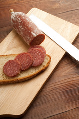 slice salami and bread over cutting board