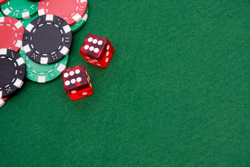Six on two dices and gambling chips on felt of casino table