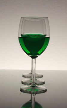three wine glasses in a row with green wine