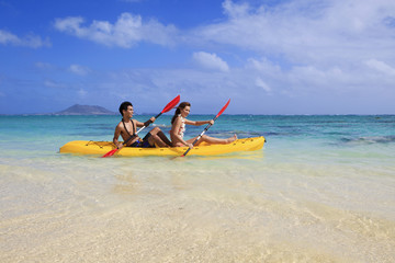 young couple kayaking in hawaii