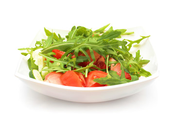 Salad from tomatoes, rucola, pepper, olive oil on white plate