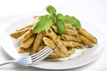 Penne with pesto decorated with basil