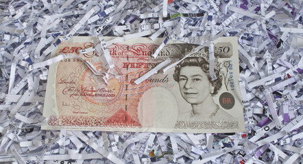 Fototapeta na wymiar fifty pound note on shredded paper