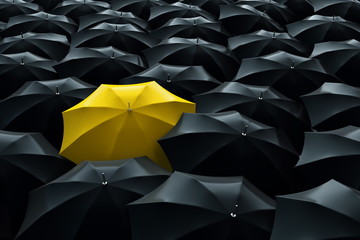 Yellow umbrella among black umbrellas