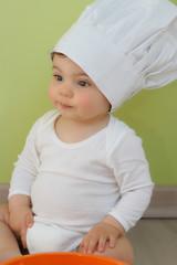 Bébé qui cuisine avec toque de chef