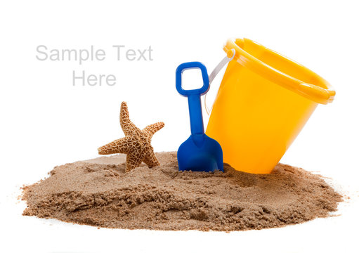 Yellow Bucket on a beach with a blue shovel and starfish