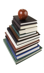 Stack of text books with apple.