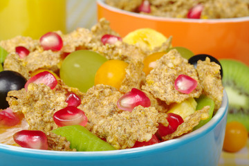 Fruits and Cereals in colorful bowls with orange juice